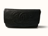 a close up of a black chanel purse on a white background