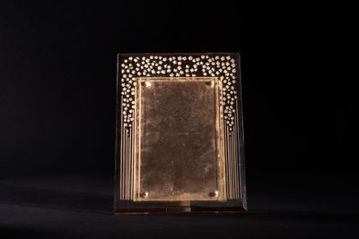 a gold plated picture frame sitting on top of a black surface