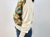 a picture of a woman wearing a white sweater and blue jeans