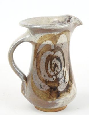 a brown and white pitcher on a white surface