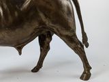 a statue of a bull that is standing on a white surface