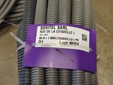 a purple label on a pile of steel pipes