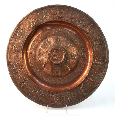 une plaque métallique ornée d'un motif, posée sur une surface blanche