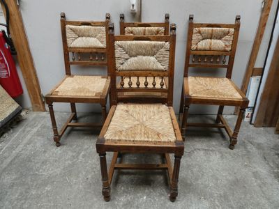 Trois chaises en bois avec des assises en osier se trouvent dans une pièce