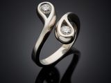 a close up of a silver ring with two diamonds on a black surface