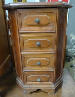 une petite commode en bois dans un coin de la pièce