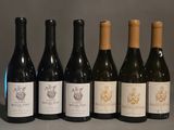 six bouteilles de vin sont alignées sur une table