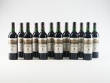 six bottles of wine lined up in a row on a white surface
