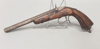 un vieux fusil exposé sur une surface blanche