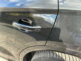 a close up of a car door handle with a reflection of the sky in the background
