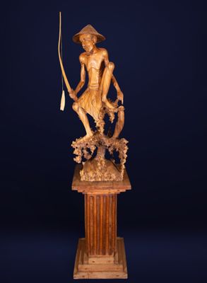 a statue of a man holding a fish on a pedestal