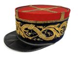 un chapeau rouge et bleu orné de décorations dorées