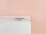 un gros plan d'une bague en diamant posée sur un bloc de marbre blanc
