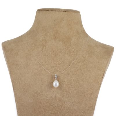 un pendentif en perle blanche et diamants au cou d'un mannequin