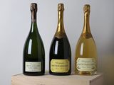 trois bouteilles de champagne dans un coffret en bois posé sur une table