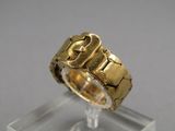 une photo d'une bague en or posée sur un socle transparent