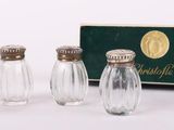 trois petites salières et poivrières en verre dans une boîte