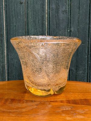 a glass vase that is sitting on a wooden table