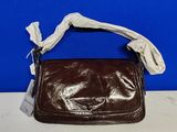 sac à main en cuir marron avec une poignée blanche sur fond bleu