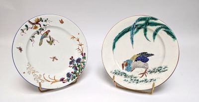 two plates with birds painted on them sitting on a table