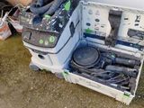 une boîte contenant un aspirateur et d'autres objets, posée par terre