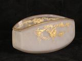 a white bowl with gold designs on it on a black background