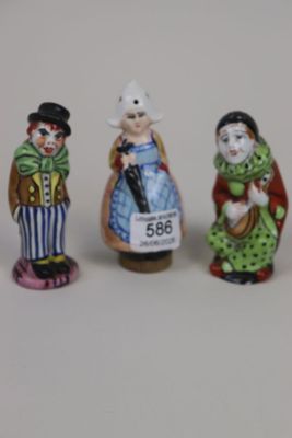 three miniature figurines of people dressed in costumes and hats