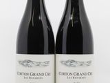 deux bouteilles de vin rouge posées l'une à côté de l'autre sur une surface blanche