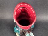 a small red vase with a blue flower on it