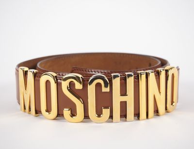 une ceinture en cuir marron sur laquelle est inscrit le mot « Moschino »