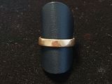 a close up of a ring with a gold band on a black surface