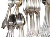 a lot of silver spoons and spoon spoons on a rack