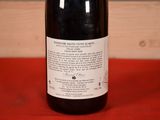 a bottle of wine sitting on a red table cloth