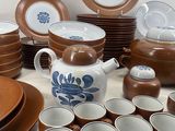 a lot of brown and white dishes and cups on the table