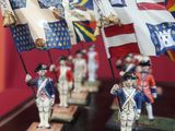 a group of figurines of soldiers holding flags on a table