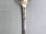 a silver spoon with a spoon handle on a table