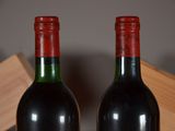 two bottles of wine sitting next to each other on a table