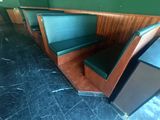 des tables et des bancs dans un restaurant aux murs verts et aux boiseries