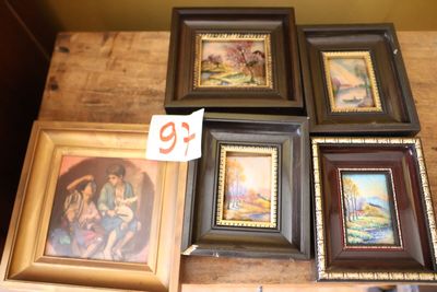 quatre photos encadrées posées sur une table, accompagnées d'une étiquette de prix