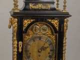 a black and gold clock sitting on a wooden table