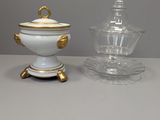 deux vases blancs et dorés posés sur une table, à côté d'un bocal en verre
