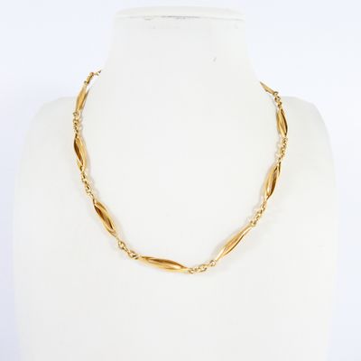 a close up of a gold necklace on a mannequin mannequin