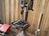 a drill on a table with a red tool in front of it