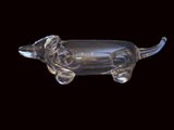 a glass dachshund figurine on a black background