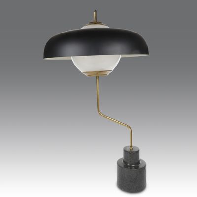 une lampe de table en noir et blanc avec un pied doré