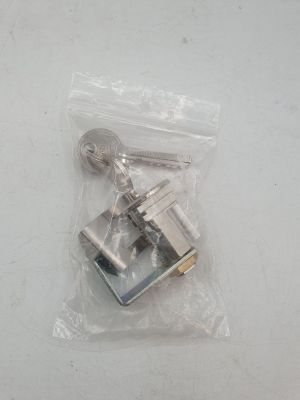 deux clés dans un sac en plastique posé sur une surface blanche