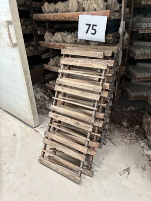 un tas de moutons posé sur une palette à côté d'un tas de bois