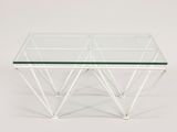 a glass and metal coffee table with three legs and a glass top