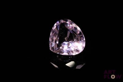 gros plan d'un diamant rose sur une surface noire