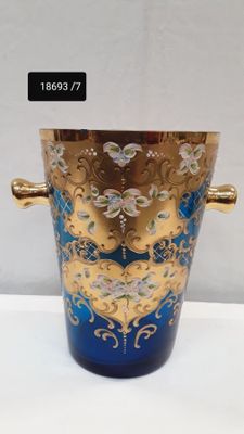a blue vase with a gold handle on a white table